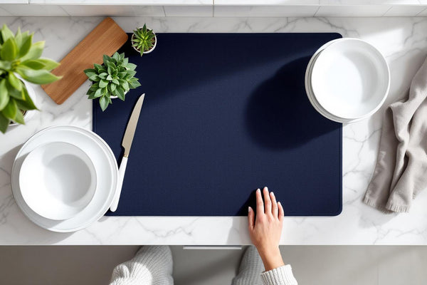 Eco friendly dish drying mat in navy blue on marble kitchen countertop with ceramic dishes