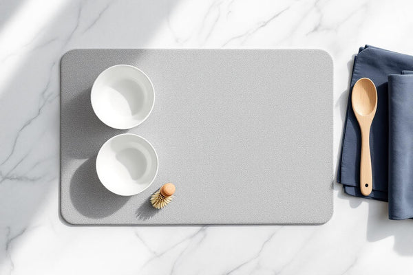 Eco friendly dish drying mat flat lay on marble surface with ceramic bowls and wood brush