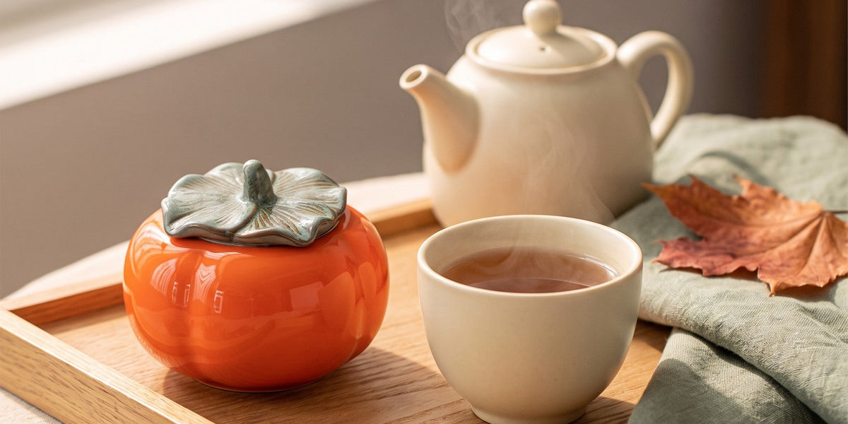 Ceramic tea caddy on a wooden tea tray beside a teapot and a cup of tea
