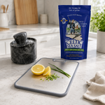 Strabella Kitchen Essentials Bundle in use — cutting board with lemon and chives next to marble salt cellar and Celtic Sea Salt