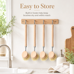 Beechwood scrub brushes hanging from a wall hook rail to dry between uses