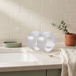 caulk tape — two clear rolls on a kitchen counter beside the sink, ready for the seam