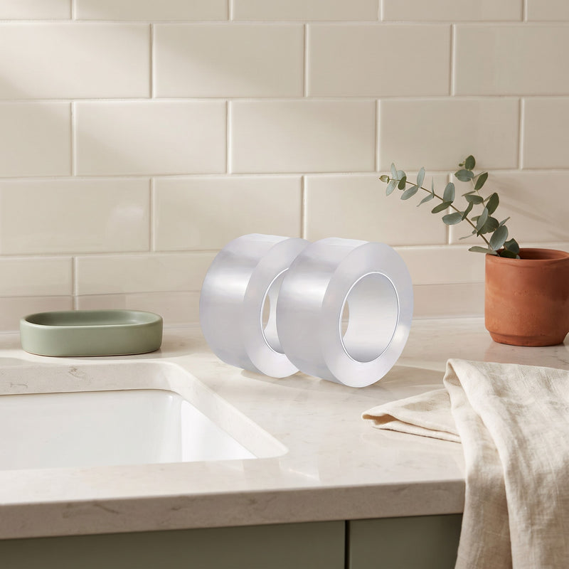 caulk tape — two clear rolls on a kitchen counter beside the sink, ready for the seam