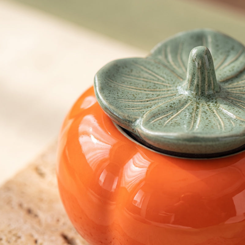 ceramic tea caddy — close-up of the leaf lid and glossy orange glaze