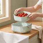 colander bowl set in use — lifting the colander insert out, water stays in the bowl