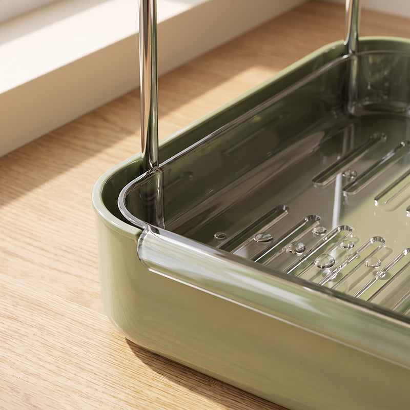 Cup drying rack detail — sage green tray corner with clear slotted drain liner and chrome post
