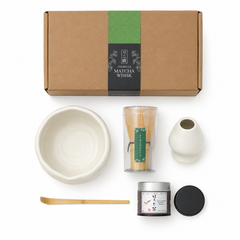 Flat lay of the white Strabella Hojicha Set — ceramic bowl, bamboo whisk, holder, scoop and stone-milled hojicha powder