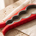 Jar opener — close-up of the red opener grip band and wave-shaped openings