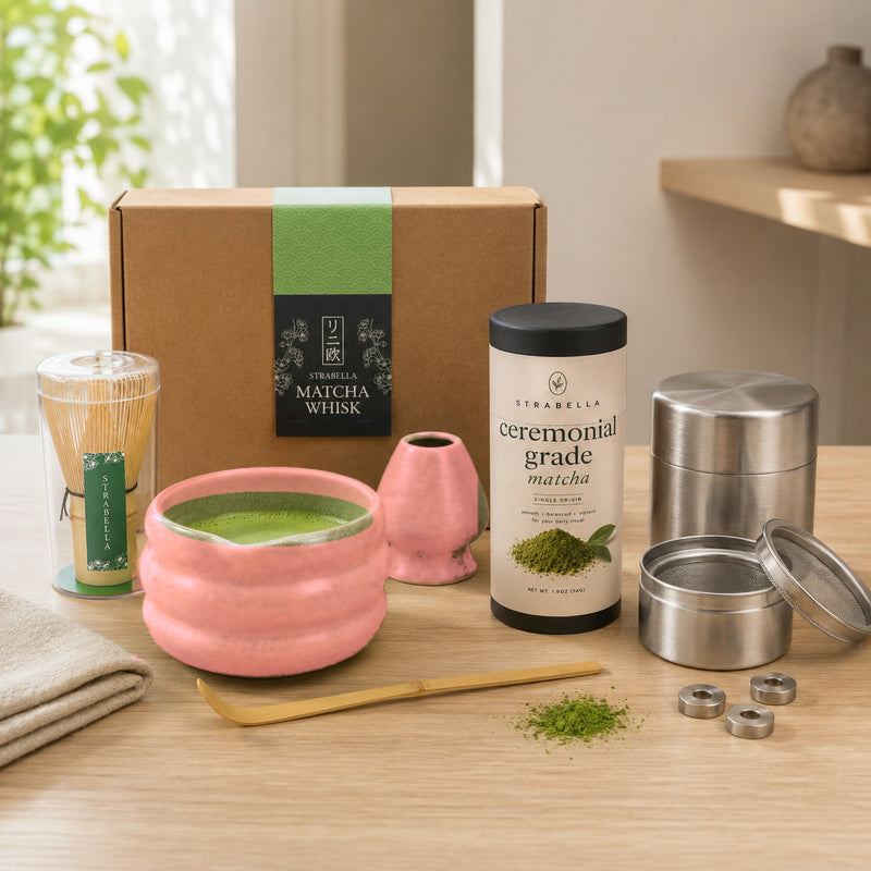 Pink 9-piece matcha starter kit on a kitchen counter with freshly whisked matcha