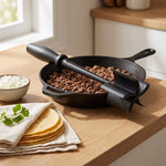 Meat chopper on a skillet of browned ground beef with tortillas and diced onion
