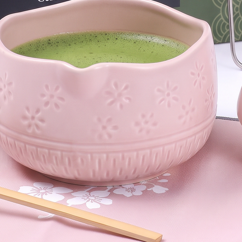 Pink ceramic matcha bowl with embossed sakura pattern and whisked matcha