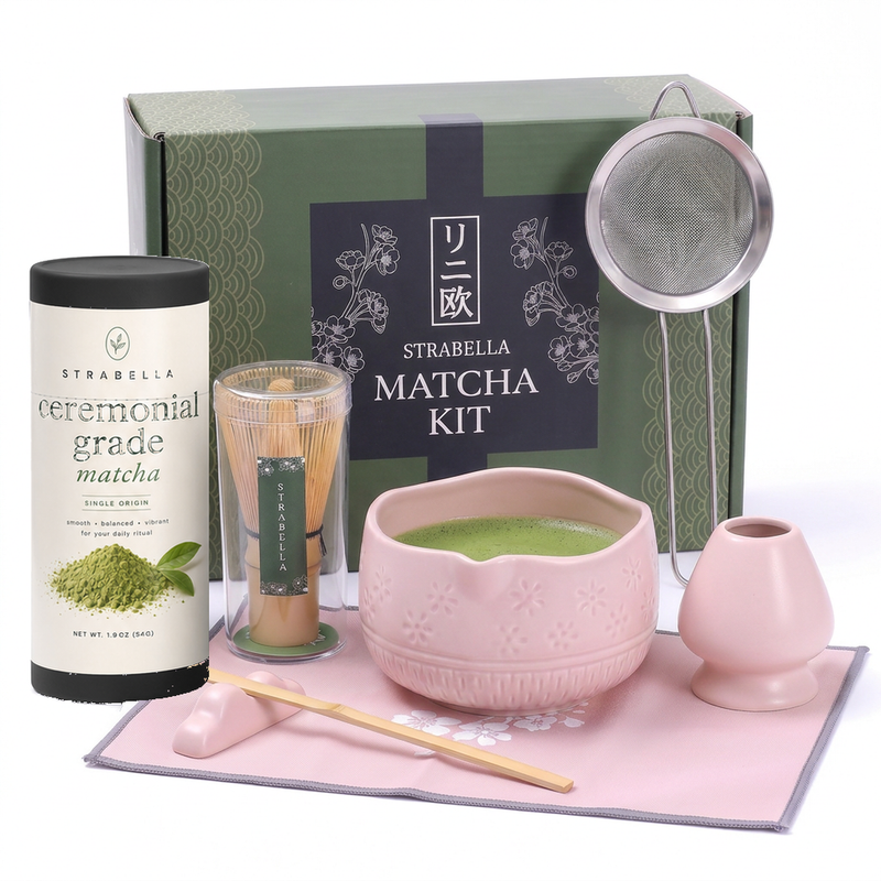 Pink matcha gift set — pink ceramic chawan, bamboo whisk, holder, sifter, ceremonial matcha tin and gift box on white