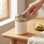 Toothpick holder — finger pressing the gold lever to lift one toothpick beside olives and cheese